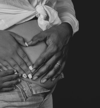 a black and white photo of a woman holding her stomach