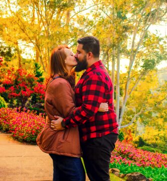 a man and a woman kissing in a garden