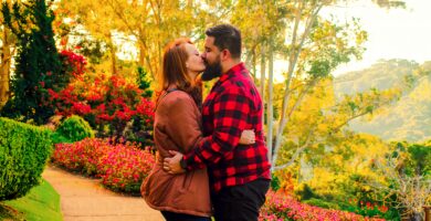 a man and a woman kissing in a garden