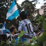 a young boy holding a blue and white flag