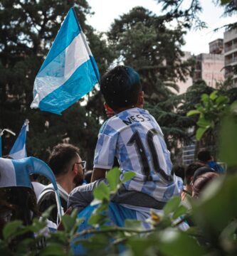 a young boy holding a blue and white flag