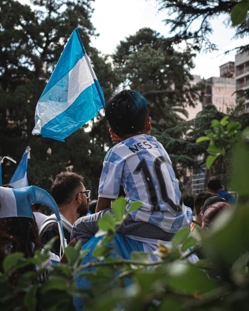 a young boy holding a blue and white flag